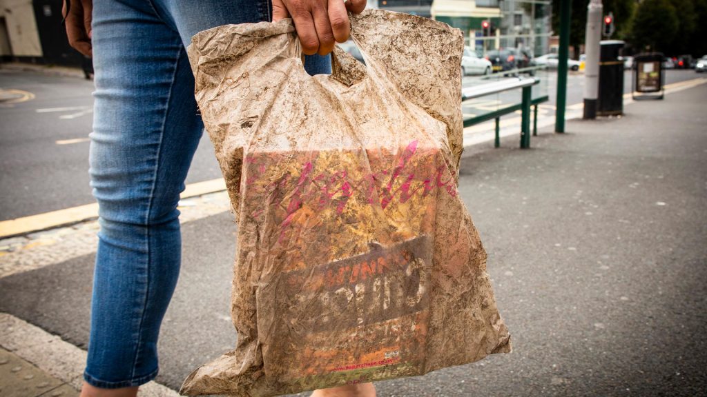 Person trägt Plastiktüte.