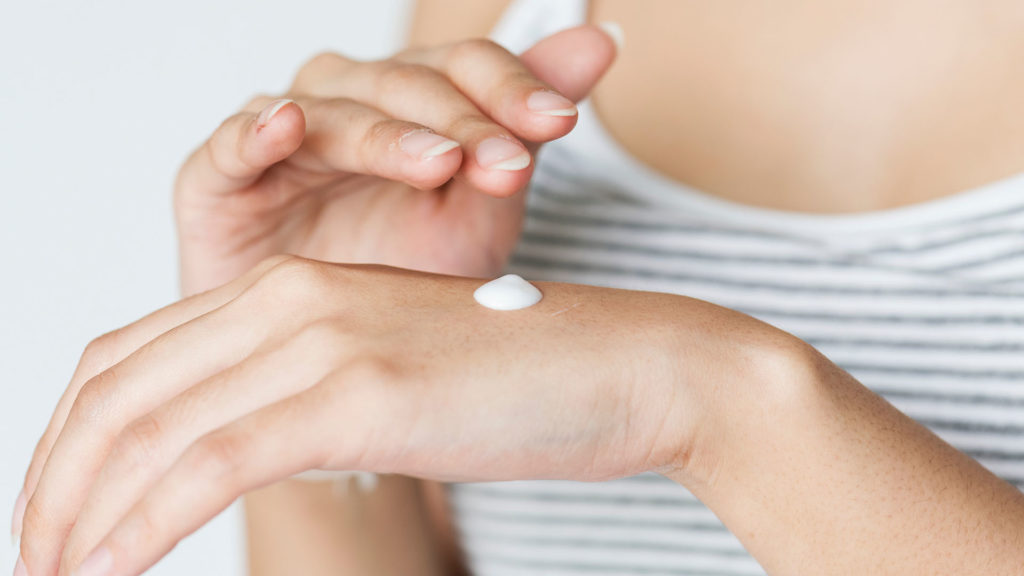 Hand einer Frau mit Creme.