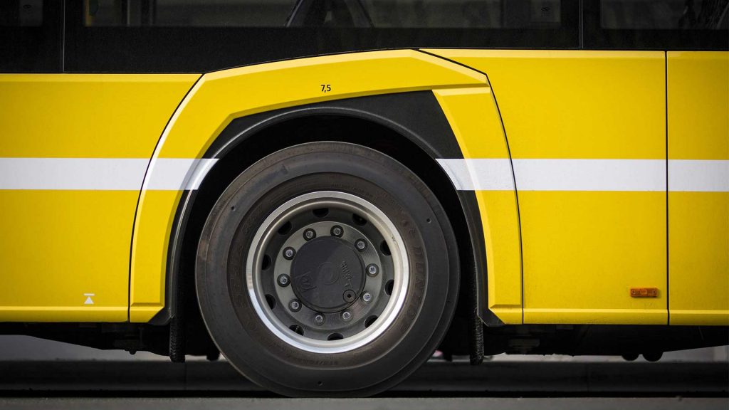 Vorderreifen eines gelben Busses.