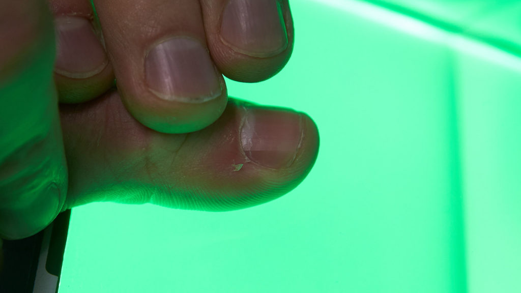 Ein Finger auf einem modernen Fingerabdruckscanner, der grün leuchtet.