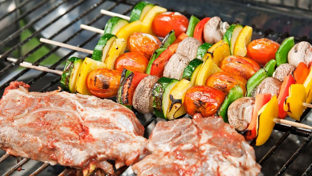 Gemüsespieße und Schweinefleisch auf einem Grill