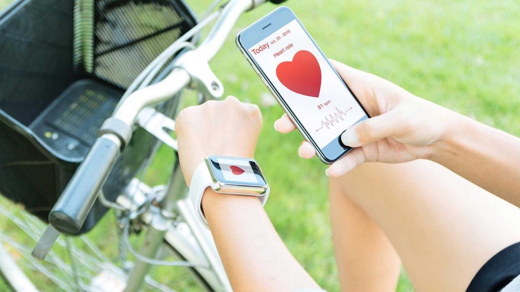 Smartphone und Smartwatch, beide mit Herz-Symbol.