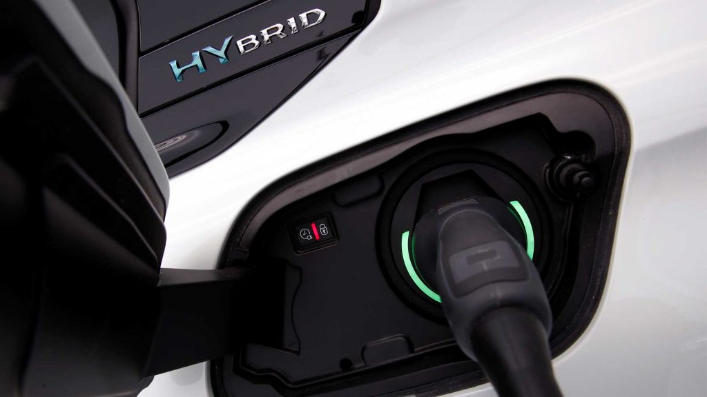 Ein Hybrid lädt an einem Stecker.