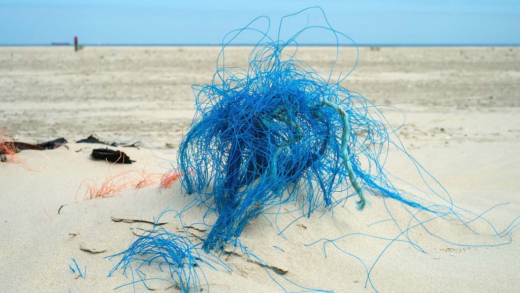 Plastikmüll und Reste von Fischernetzen liegen am Strand