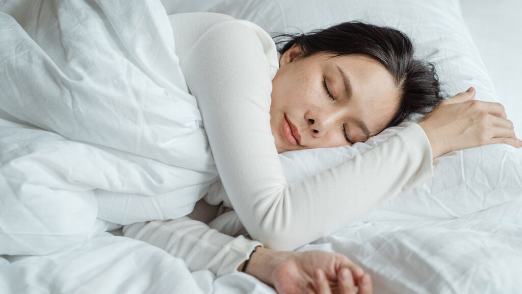 Schlafende Frau im Bett mit Handy