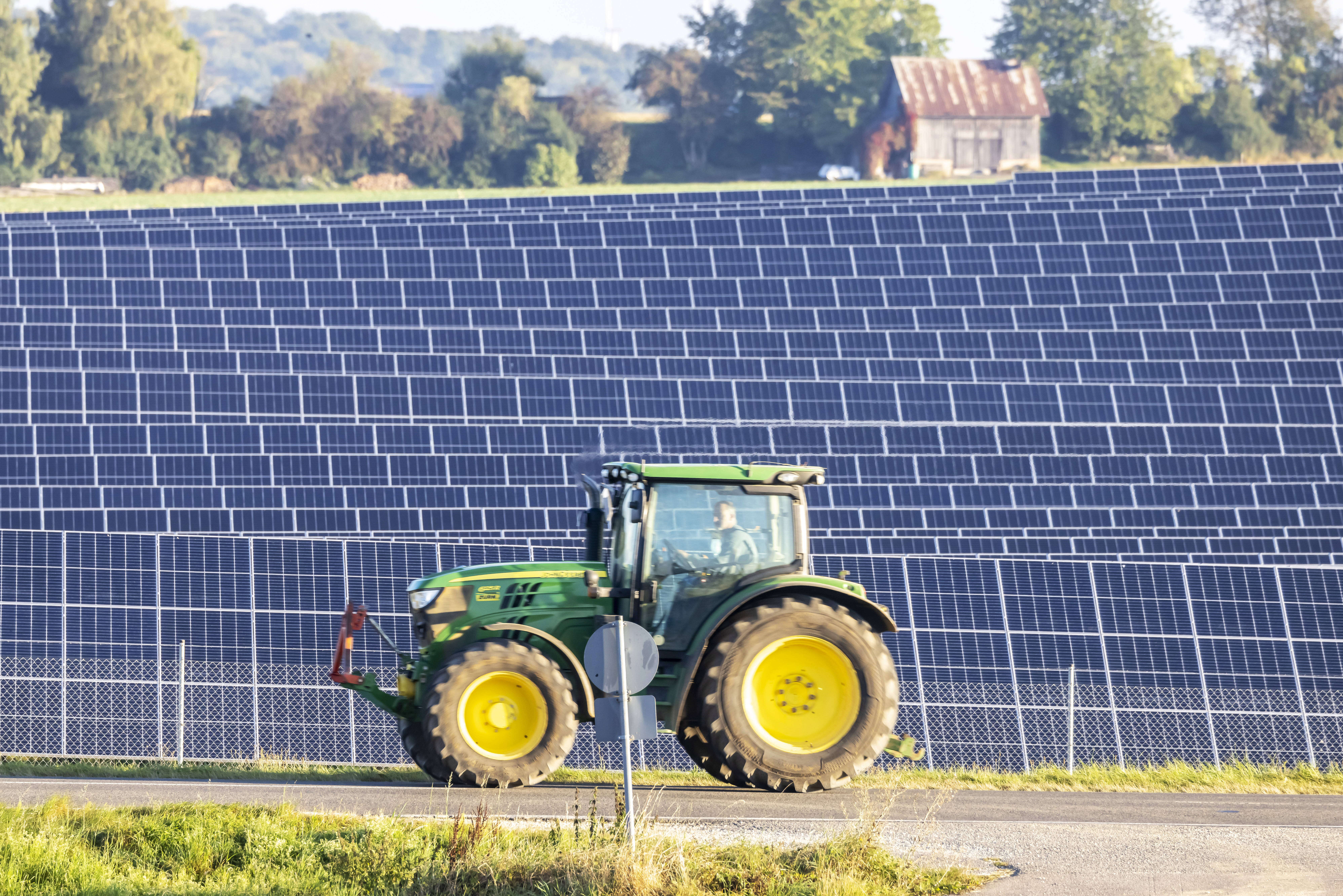 Fotovoltaik / Solaranlage auf Feldern und Wiesen - Symbolbilder Feld auf der Schwäbischen Alb mit Photovoltaik-Anlage mi Traktor vor Solarpark
