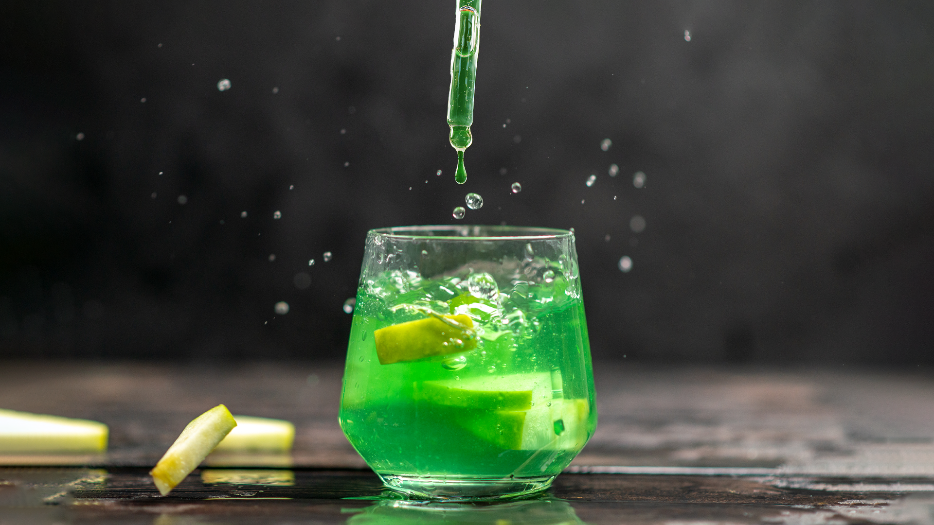 Grüner Drink über dem eine Pipette mit K.O.-Tropfen schwebt.