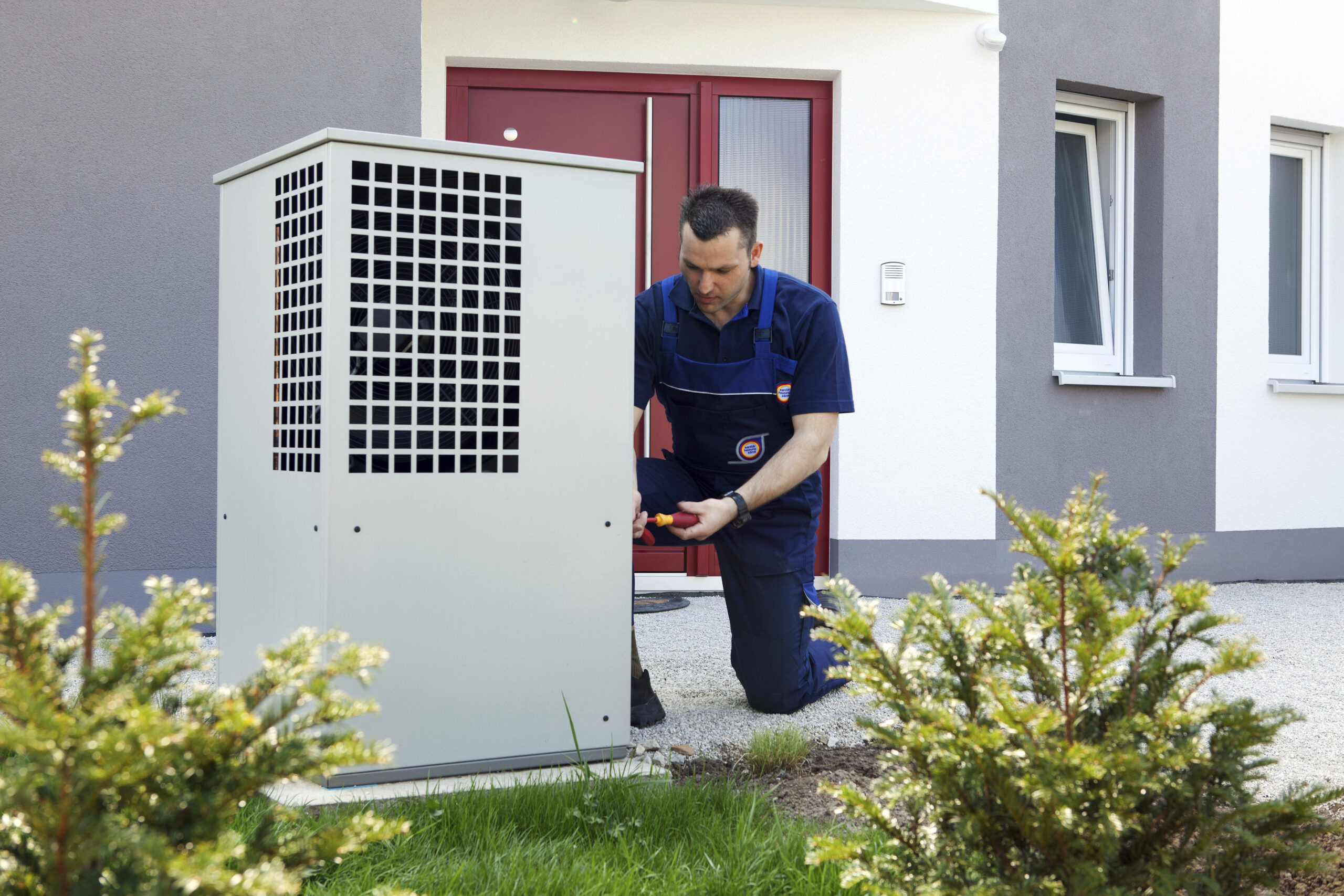 Sanitär - Heizung - Klima Ein Heizungsmonteur montiert das Gehäusefür eine Wärmepumpe im Rahmen einer Heizungsmodernisierung