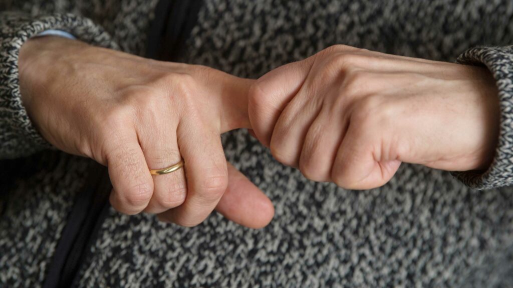 Nahaufnahme - Mann zieht an seinem Zeigefinger.