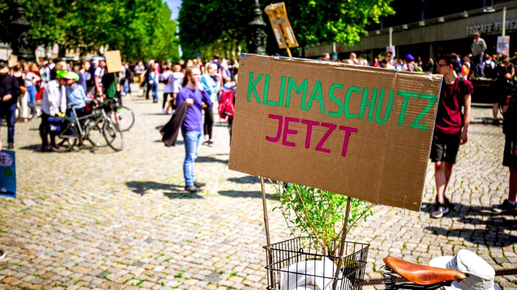 Schild "Klimaschutz jetzt" auf einer Demo