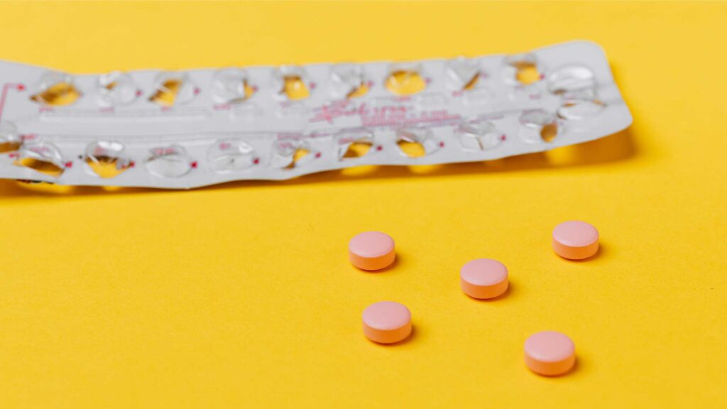 Eine leere Pillenverpackung, davor fünf einzelne Pillen. Bild: Karolina Grabowska/Pexels